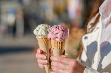 İki renkli dondurma külahı bir kızın ellerinde..