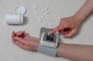 Kadın kan basıncını ve kalp atış hızını dijital basınç göstergesiyle ölçüyor. Sağlık ve Tıp Konsepti