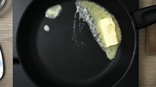 在黑色铸铁煎锅上融化的奶油垫 用融化的黄油在炉子上烤锅 — 图库视频影像
