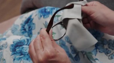 Kadınlar gözlük lenslerini mikrofiber bezle elle temizlerler. Sağlık, görme ve tıp konsepti