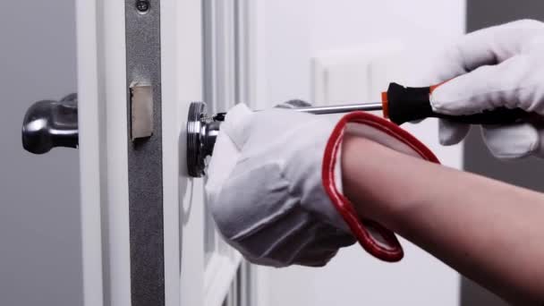 一个戴白色手套的杂工正在修理门上的锁 工人手部安装新门锁的特写 — 图库视频影像