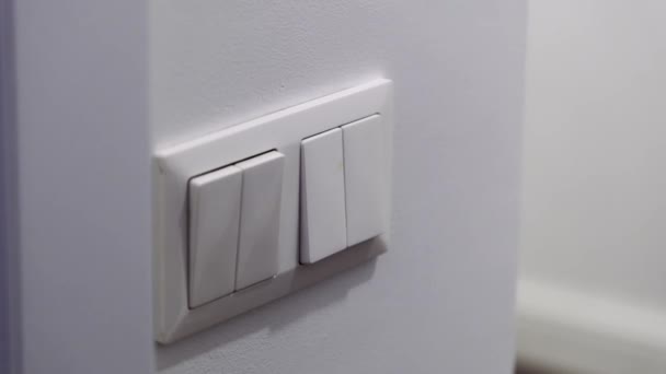 一个女人的手指的特写关掉了房子里的灯 关掉电灯以节省能源 — 图库视频影像