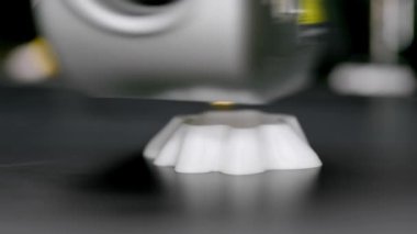 Bir 3D baskı makinesi plastikten teknik bir ürün basar. Çalışan 3D yazıcı başlığı.
