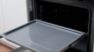 Mangırı fırına koyan ellerin yakın çekimi. Aşçı ekmek pişirir..