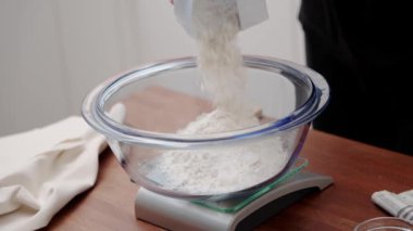 Aşçı ekmek pişirmek için unu ölçer. Aşçı hamuru tarifine göre yoğurur..