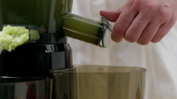 一个女人从榨汁机里喝蔬菜汁 健康的排毒素食 配以冷榨植物提取物作为面包和面食 — 图库视频影像