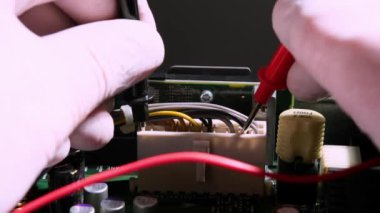 Bir zanaatkârın ellerinin problarla yakın çekimi. Anakart testçisi. Onarım ve tanı konsepti.