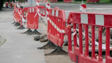 Kırmızı çit geçidi kapatıyor. Yol onarımı sırasında yayaları korumak için inşaat bariyerleri.