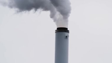 Gökyüzüne doğru beyaz dumanlı bir boru. Atmosfere duman ve buhar salıyor.