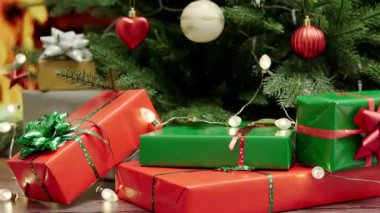 Güzel dekore edilmiş bir Noel ağacının altına parlak bir hediye kutusu yerleştirmek. Şenlikli hediyelerle.
