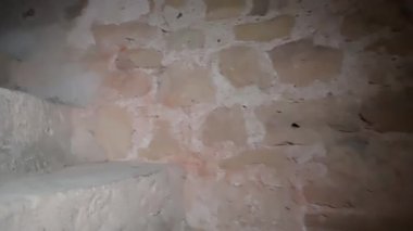 Yıpranmış duvarları ve doğal ışık atmosferi olan tarihi kırsal bir binada antik taş merdivenler.