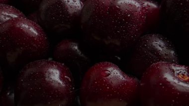 Su damlacıklarıyla taze kirazların yakın plan görüntüsü canlı doğal dokular ve zengin kırmızı renkler sergiliyor.