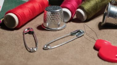 Craft Studio 'nun Kumaş Yüzeyinde Renkli Dikiş İplikleri ve Temel Terzilik Araçlarının Yakın Çekimi