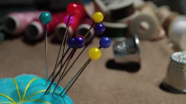 İşletme Atölyesinde İplik ve Yüksüklerle Mavi İğneye Sıkışan Renkli Dikiş İğneleri