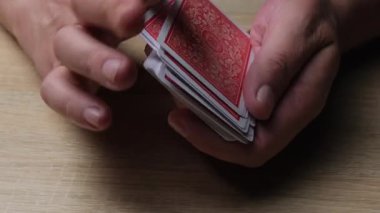 Kart Oyunları ve Sihirli Numaralar için Tahta Yüzey Üzerinde Elleri Karıştırma Kırmızı Kartlarını Yakın plan