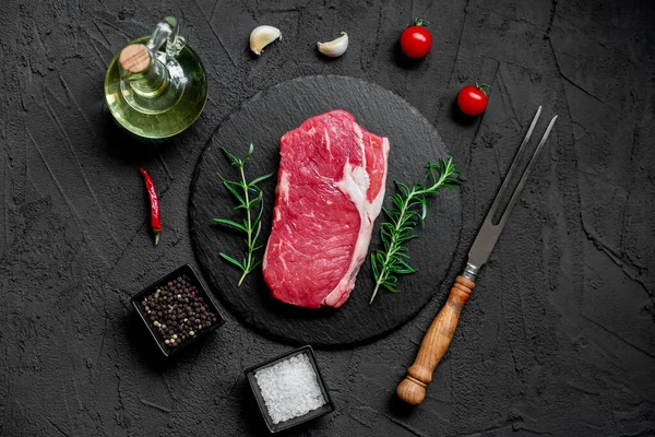 Rauwe Biefstuk Met Specerijen Kruiden Zwarte Achtergrond Bovenaanzicht — Stockfoto