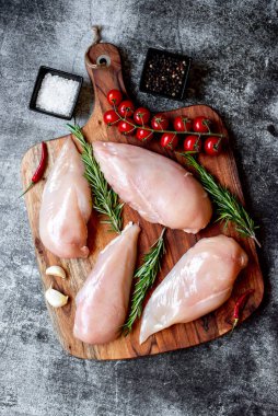 Taş arka planda dört çiğ tavuk göğsü, üst manzara.