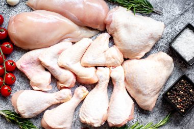 Taş bir arka planda çiğ tavuk filetosu, but, kanat ve bacak seti. 
