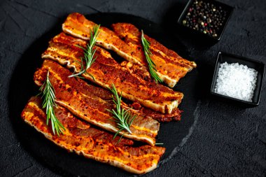 Siyah taş zemin üzerinde çiğ domuz eti dilimleri