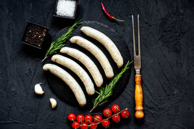 Siyah taş zemin üzerinde çiğ Alman sosisleri