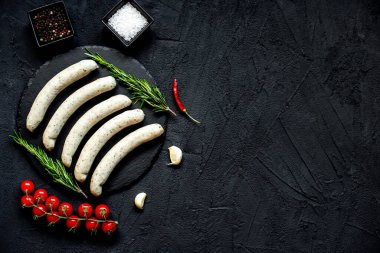 Siyah taş zemin üzerinde çiğ Alman sosisleri
