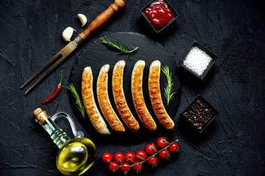 Siyah taş zemin üzerinde ızgara sosisler, üst görünüm
