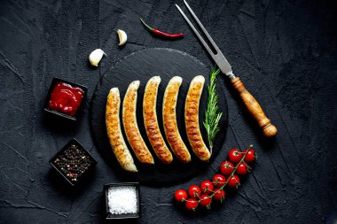 Siyah taş zemin üzerinde ızgara sosisler, üst görünüm