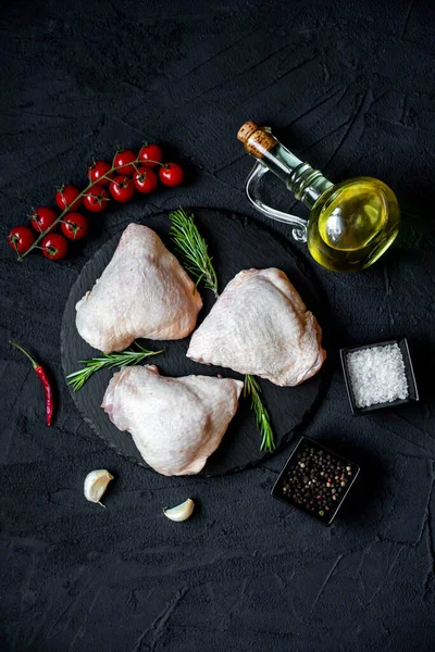 stock image raw chicken thighs on black stone background