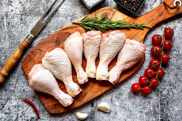 Stock image raw chicken legs on wooden board, top view