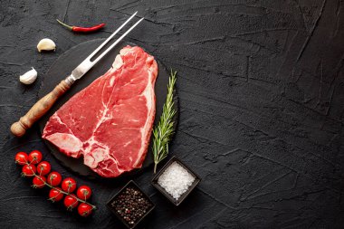 Siyah arka planda baharatlı ve otlu çiğ biftek. en üstteki görünüm.