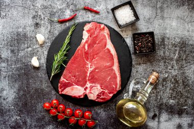 Siyah taş tahtada çiğ et bifteği. Üst görünüm, düz uzanma
