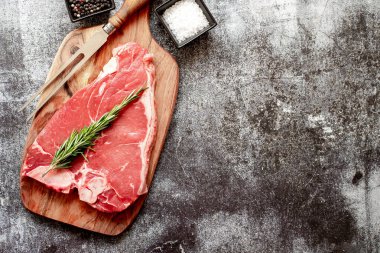 Taştan arka planda pişirmek için malzemeli çiğ biftek. en üstteki görünüm