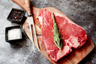 Baharatlı çiğ biftek ve taş zeminde otlar.