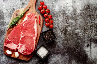 Baharatlı çiğ biftek ve taş zeminde otlar.