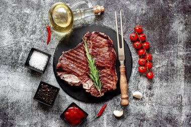Biberiyeli ızgara biftek ve siyah taş tahtada baharatlar.