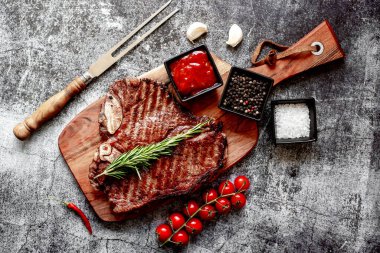 Baharatlı ızgara biftek ve ahşap tahtada biberiye.