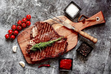 Baharatlı ızgara biftek ve ahşap tahtada biberiye.
