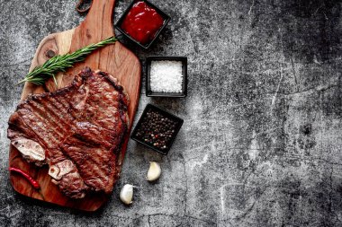 Ahşap tahtada baharatlı ve otlu ızgara biftek. Üst Manzara. Boşluğu kopyala.