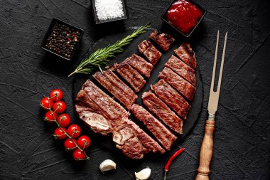 Baharatlı ızgara biftek ve siyah arka planda biberiye.