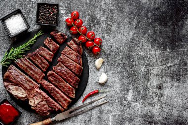 Baharatlı ızgara biftek ve siyah taş tahtada doğranmış biberiye, kopyalama alanı.