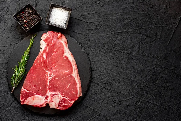Baharatlı ve biberiyeli çiğ biftek. koyu arkaplan.