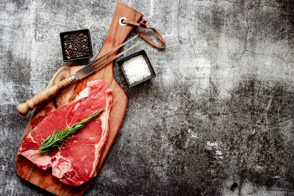 Baharatlı çiğ biftek ve taş zeminde otlar.