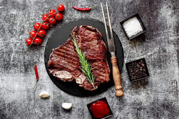 Grilovaný Hovězí Steak Rozmarýnem Kořením Černé Kamenné Desce Pohled Shora — Stock fotografie