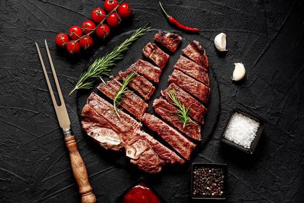 Gesneden Gegrilde Biefstuk Met Specerijen Rozemarijn Zwarte Achtergrond Bovenaanzicht — Stockfoto