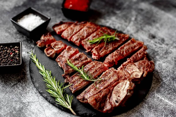 Gegrilde Biefstuk Met Specerijen Rozemarijn Stukken Gehakt Zwarte Stenen Plank — Stockfoto