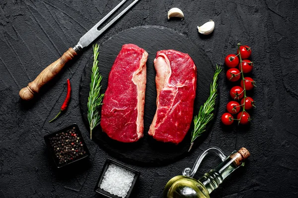 Rauwe Biefstuk Met Specerijen Kruiden Zwarte Stenen Achtergrond — Stockfoto