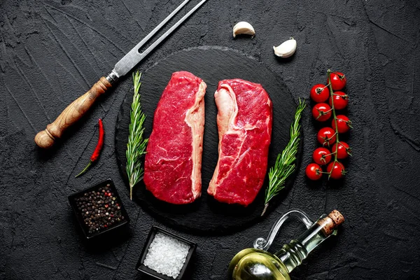 Rauwe Biefstuk Met Specerijen Kruiden Zwarte Stenen Achtergrond — Stockfoto