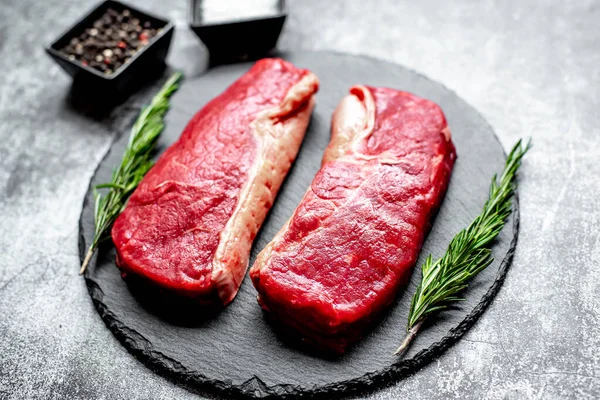 Baharatlı Çiğ Biftek Siyah Taş Arka Planda Otlar — Stok fotoğraf