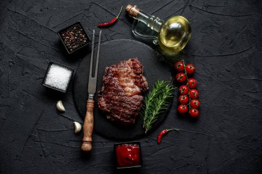 Siyah arka planda baharatlı ızgara biftek.