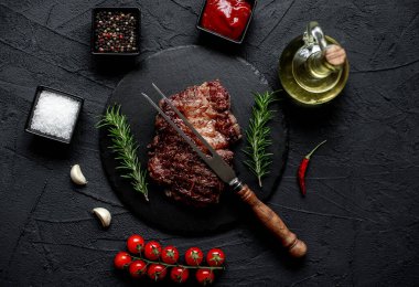 Siyah arka planda baharatlı ızgara biftek.